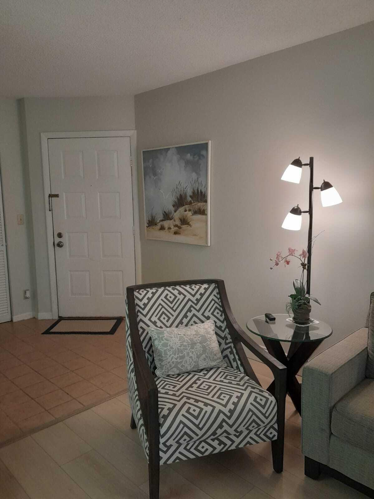 1605 Highway 1, Unit C302 Jupiter, FL 33477 - Photo 5 of 30 a bedroom with a bed and a lamp