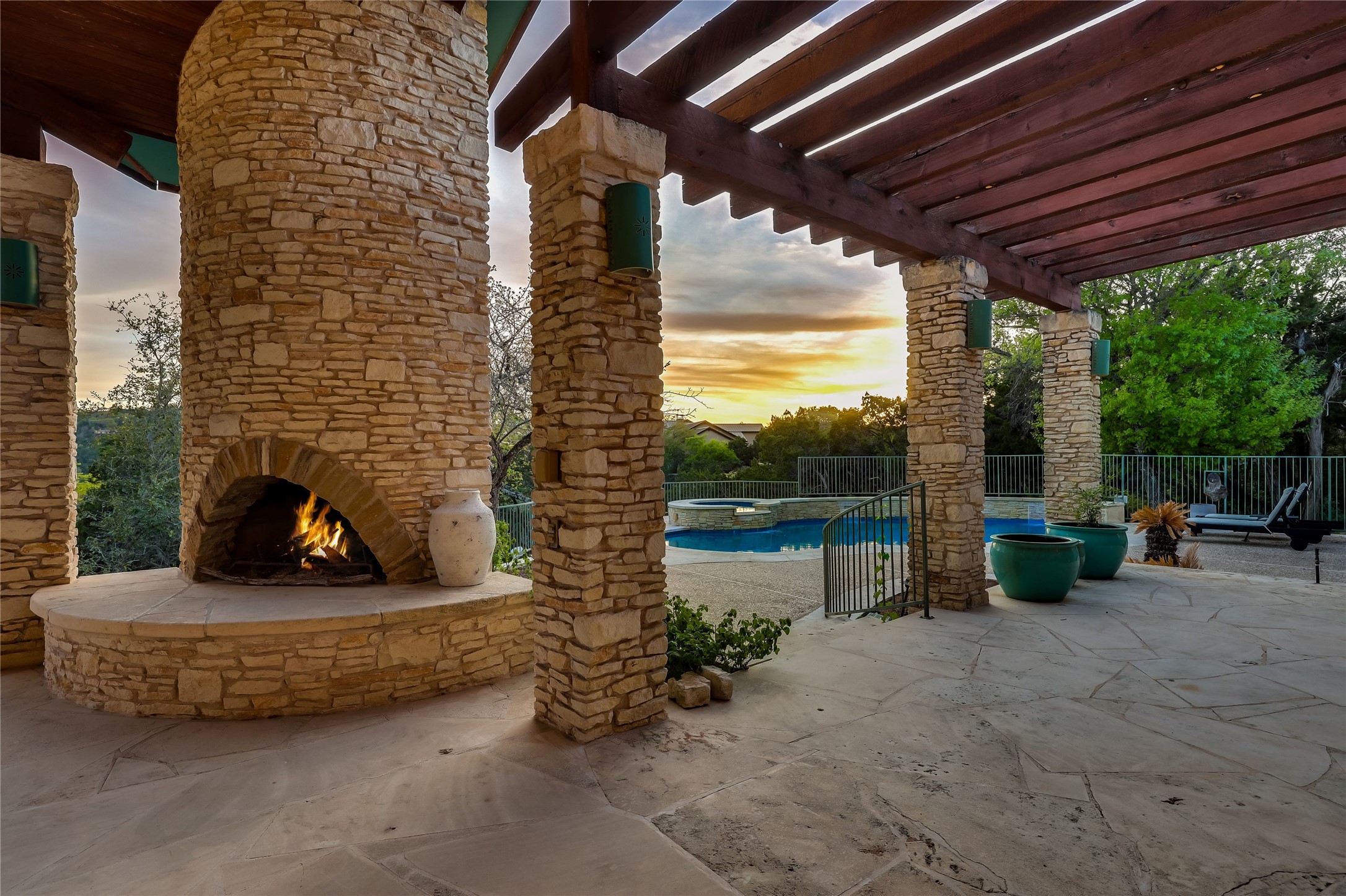 1016 Wild Basin Ledge Austin, TX 78746 - Photo 27 of 38 View of terrace with an outdoor stone fireplace, a pergola, and a pool
