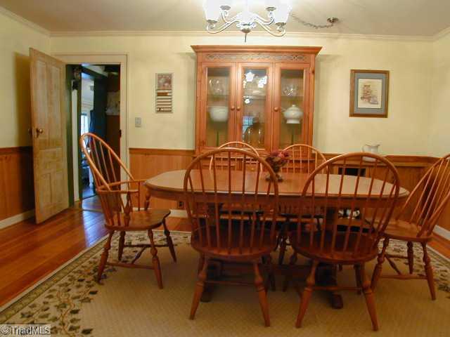 3136 Baltimore Road East Bend, NC 27018 - Photo 6 of 16 Dining Room. Large formal dining room showing door to kitchen, pine floors, chair rail and wainscotting.