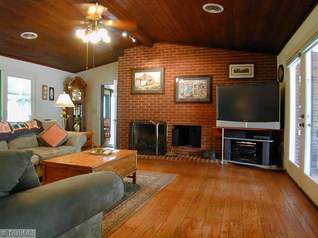 3136 Baltimore Road East Bend, NC 27018 - Photo 9 of 16 Den/Family/Great Room. Great Room with pegged wooden floors with Sunroom to the left and Patio/Pool area to the right. 56"DLP HDTV & sound system convey with the home