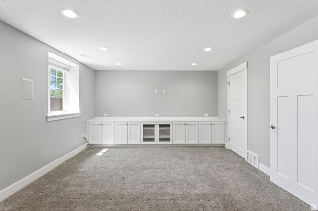 1614 Aspen Loop Provo, UT 84606 - Photo 29 of 47 Spacious room featuring extensive built-in cabinetry with a countertop, recessed lighting, a single window, and neutral carpeting