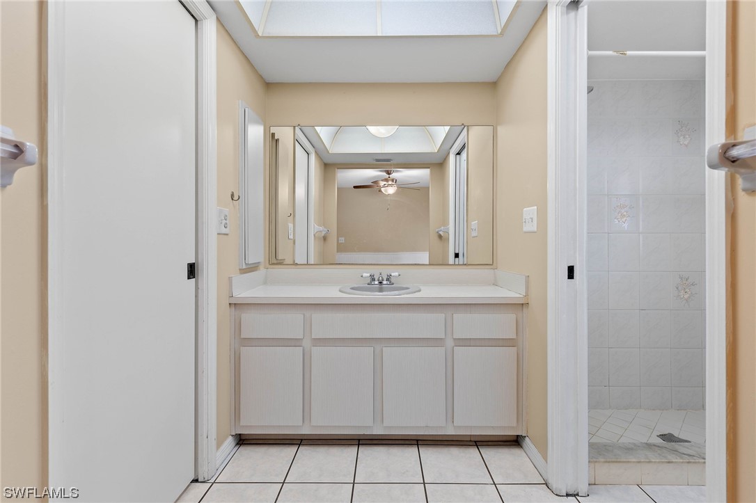 17568 Fuchsia Road Fort Myers, FL 33967 - Photo 15 of 31 a bathroom with a granite countertop sink a mirror and a shower