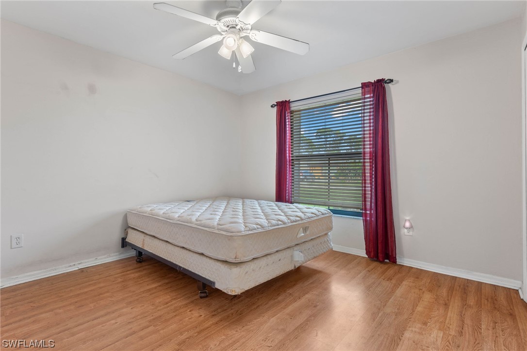 17568 Fuchsia Road Fort Myers, FL 33967 - Photo 18 of 31 a spacious bedroom with a bed and a chandelier