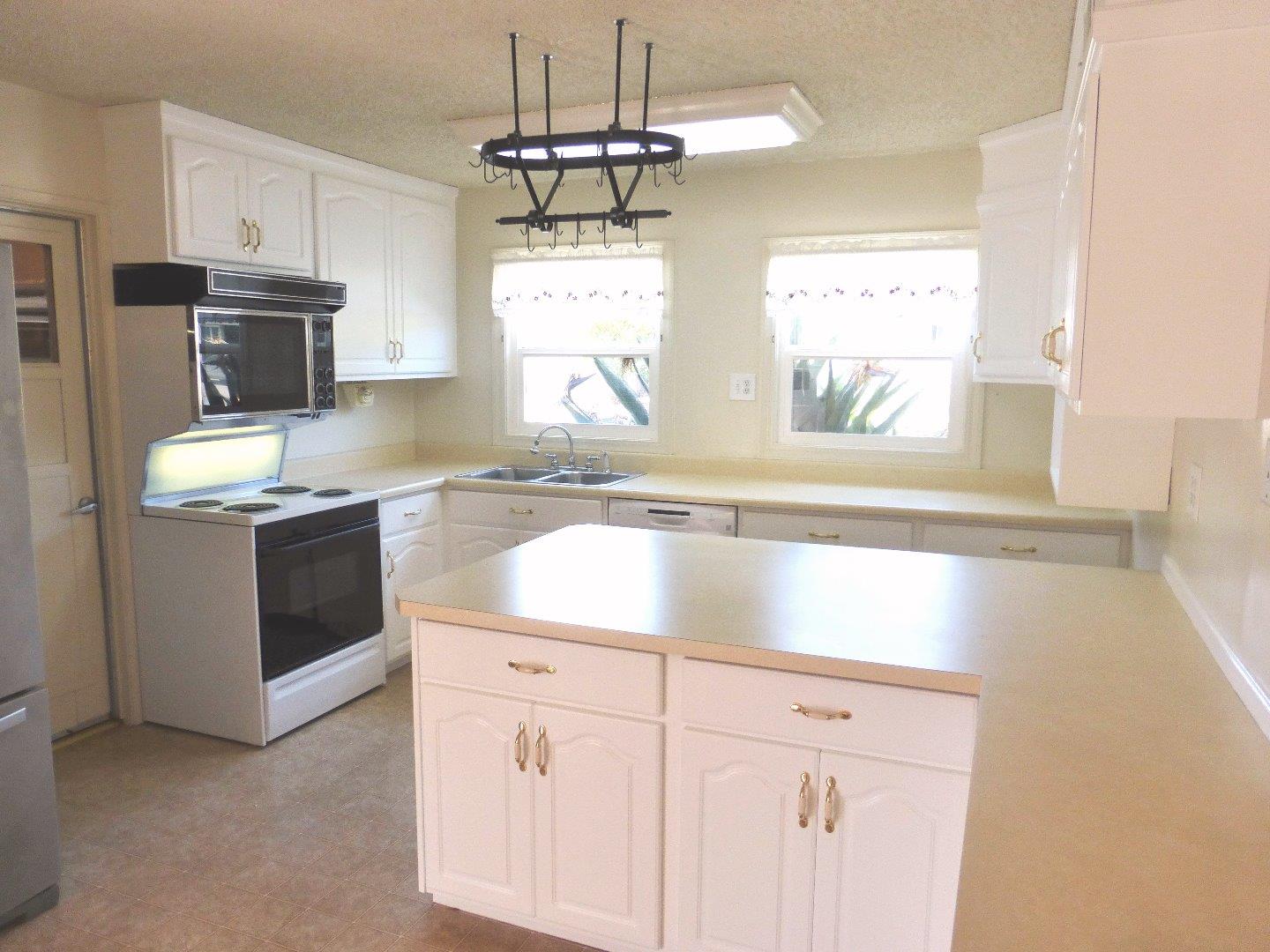 455 Helen Drive Millbrae, CA 94030 - Photo 12 of 29 a kitchen with stainless steel appliances white cabinets and window