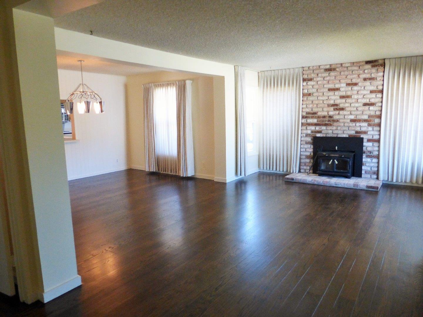 455 Helen Drive Millbrae, CA 94030 - Photo 5 of 29 an empty room with wooden floor and fireplace