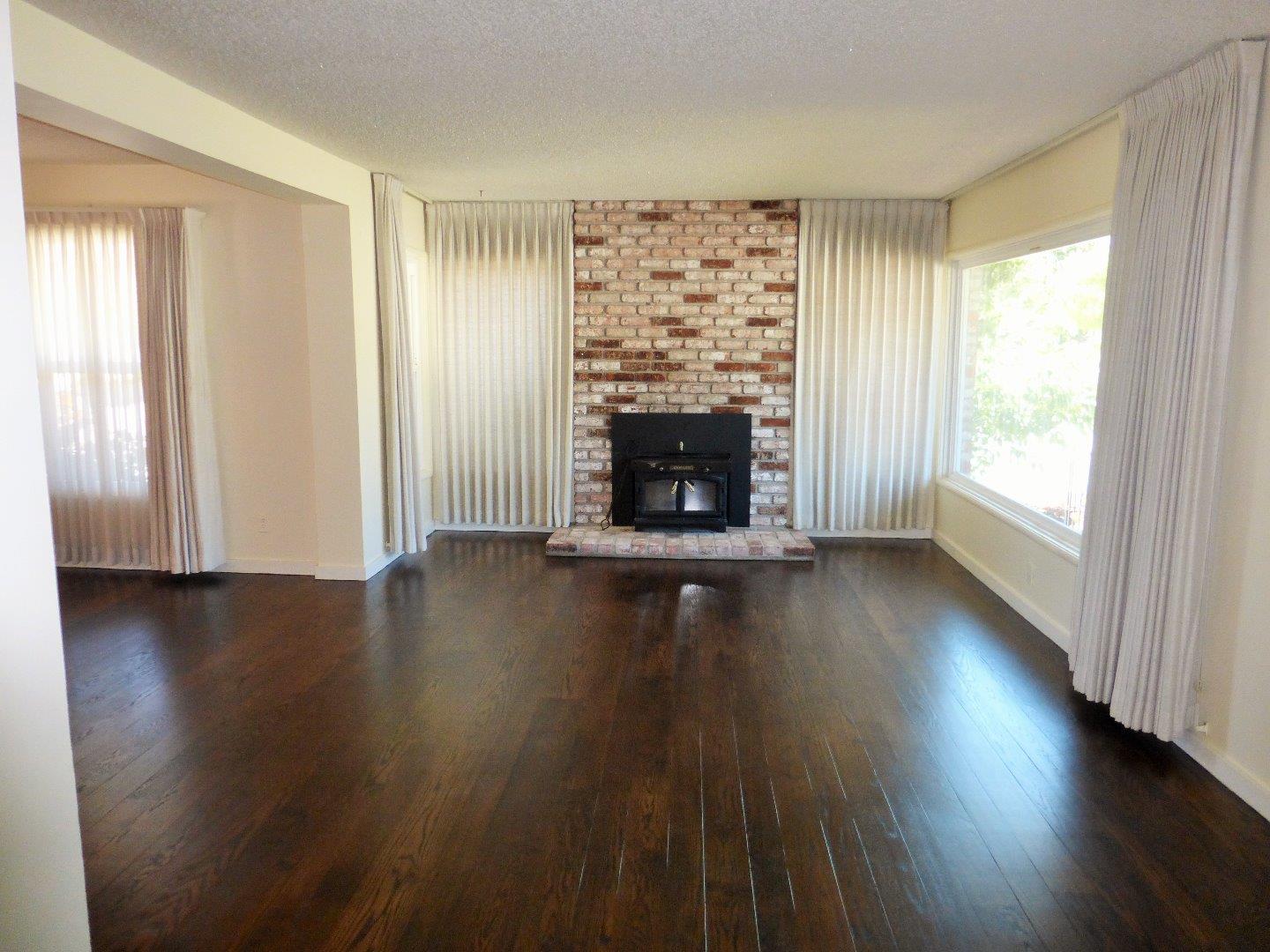 455 Helen Drive Millbrae, CA 94030 - Photo 6 of 29 an empty room with wooden floor and fireplace
