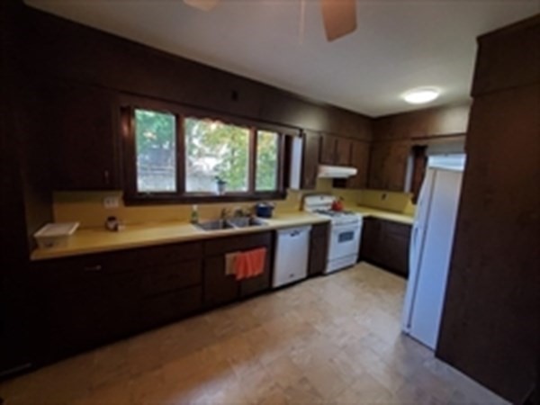 29 Bartlett Crescent Brookline, MA 02446 - Photo 19 of 27 a large kitchen with a sink a window and stainless steel appliances
