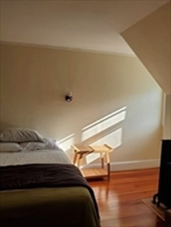 29 Bartlett Crescent Brookline, MA 02446 - Photo 4 of 27 a bedroom with a bed and a flat tv screen on the dresser