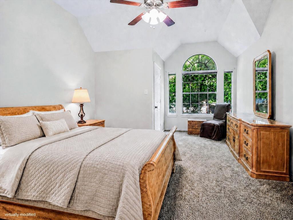 14592 Greenleaf Court Addison, TX 75001 - Photo 13 of 34 Vaulted ceiling room featuring an arched window, a ceiling fan with light fixture, and light-toned carpeting