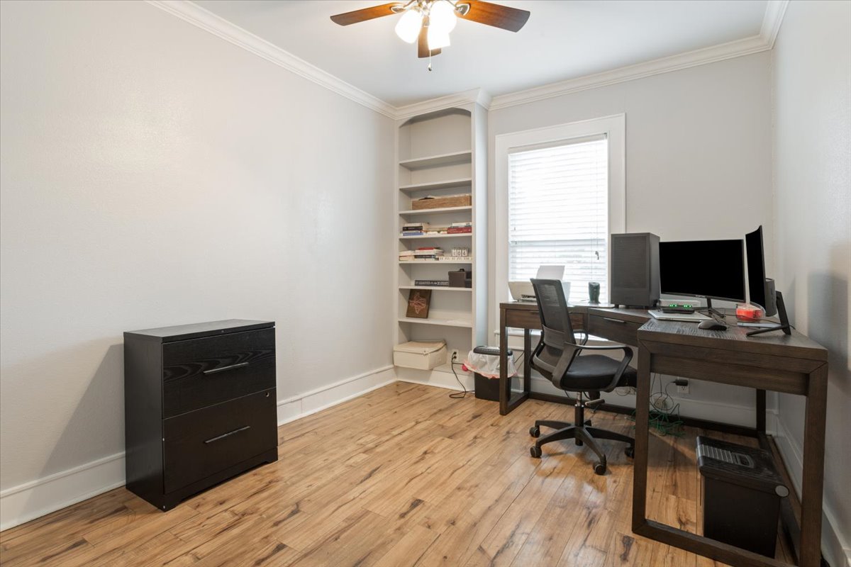 1607 North Harding Avenue Cameron, TX 76520 - Photo 26 of 37 Functional home office with built-in shelving, crown molding, and beautiful flooring.