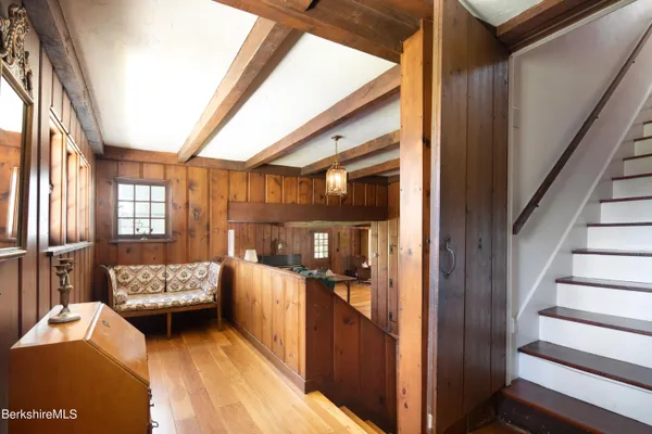 a room with stainless steel appliances kitchen island granite countertop a table chairs in it and wooden floors