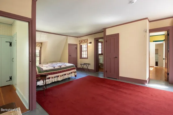 a living room with stainless steel appliances a dining table wooden floor and a large window