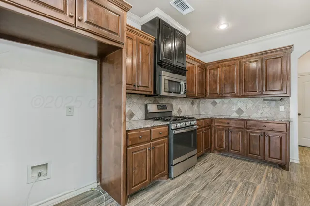 a kitchen with stainless steel appliances granite countertop a stove cabinets and a refrigerator