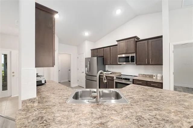 a kitchen with granite countertop a stove and a microwave