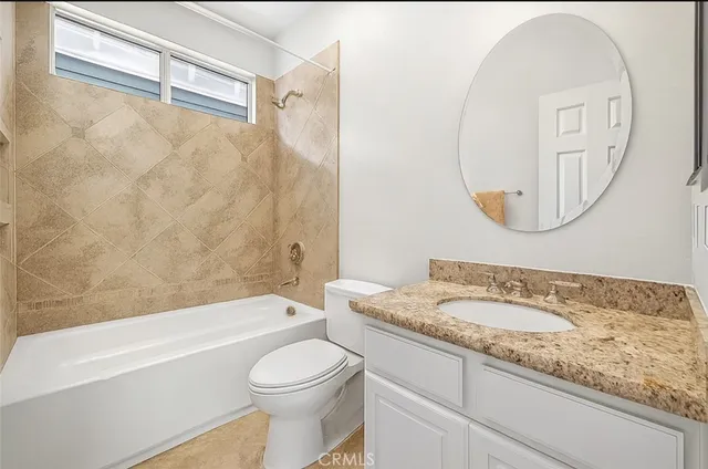 a bathroom with a granite countertop sink a toilet and bathtub