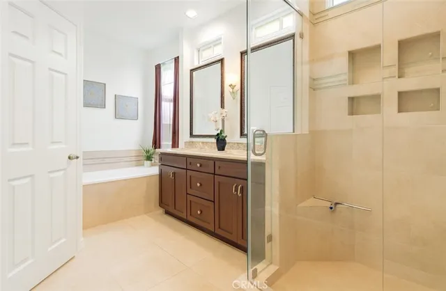 a bathroom with a tub sink shower and mirror