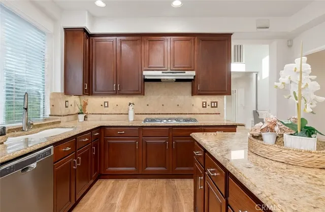 a kitchen with kitchen island granite countertop a sink stove and cabinets