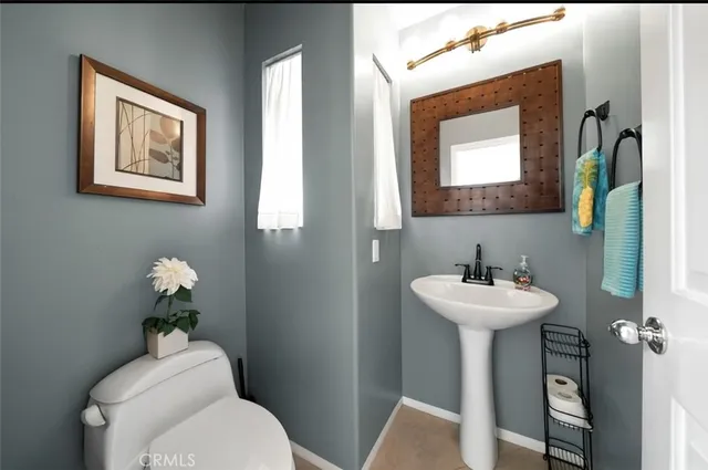 a bathroom with a toilet sink and mirror