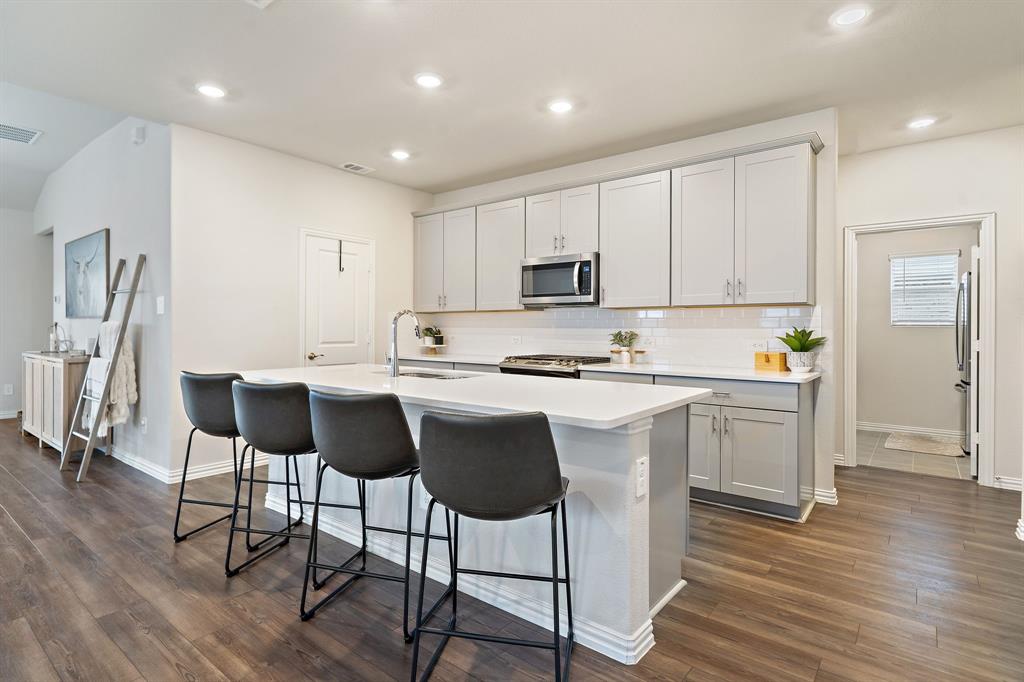 2232 Sun Star Drive Haslet, TX 76052 - Photo 7 of 40 a kitchen with a dining table chairs and white stainless steel appliances