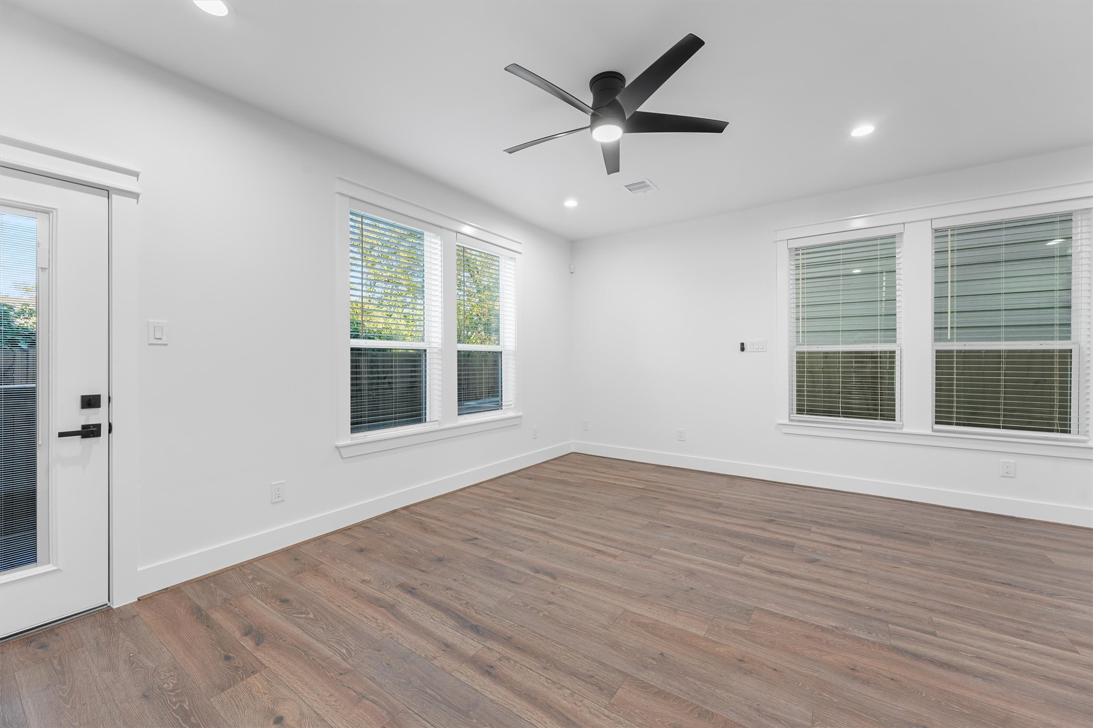 4208 Castor Street, Unit A Houston, TX 77022 - Photo 10 of 23 an empty room with wooden floor and windows