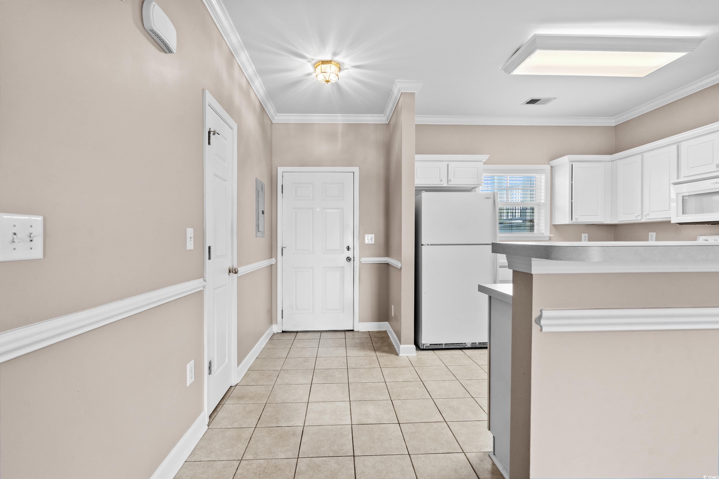 336 Kiskadee Loop, Unit B Conway, SC 29526 - Photo 6 of 40 Kitchen with white appliances, crown molding, white cabinetry, and light tile patterned floors