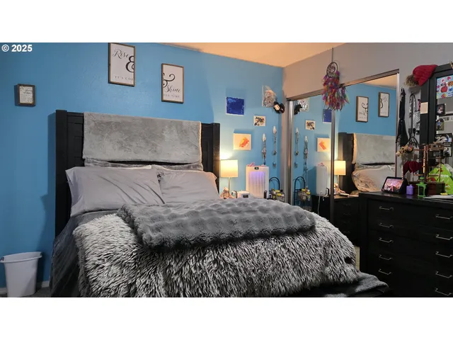 a room with a bed mirror and a night stand