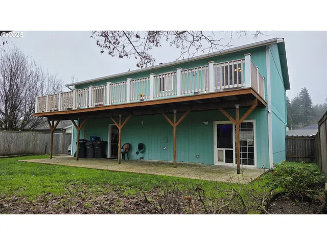 a view of a grey house with a yard