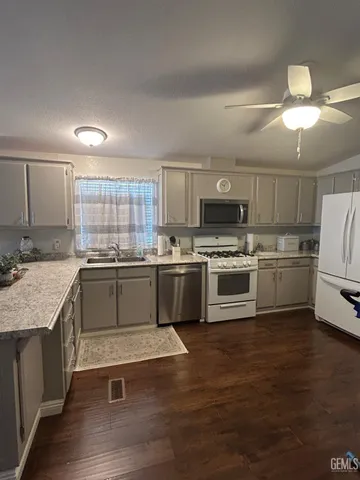 a kitchen with a sink stainless steel appliances and white cabinets