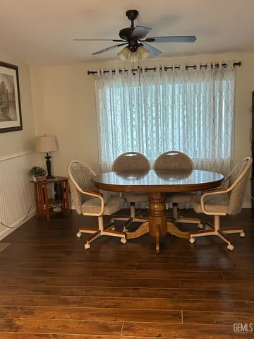 a room with wooden floor pool table and chairs