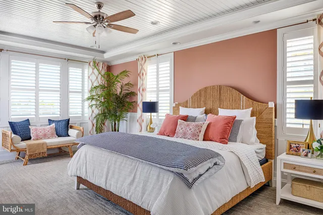 a bedroom with a bed a couch and a large window