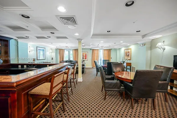 a dining hall with stainless steel appliances granite countertop a dining table and chairs