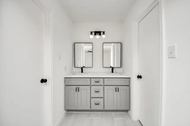 a bathroom with a granite countertop sink and a mirror