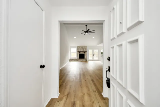a view of a hallway with wooden floor and staircase