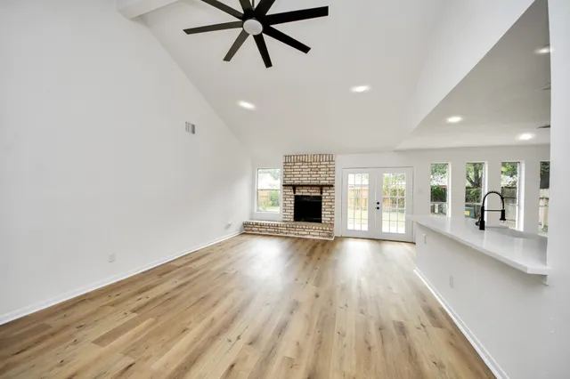 an empty room with wooden floor and a fireplace
