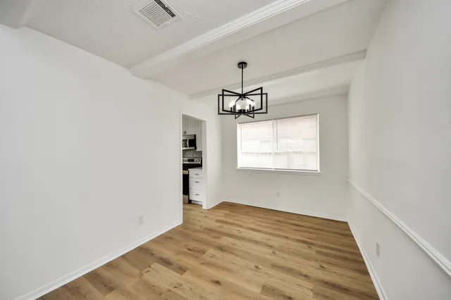 a view of empty room with wooden floor and ceiling fan