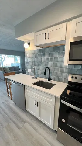 a kitchen with a sink stove and cabinets
