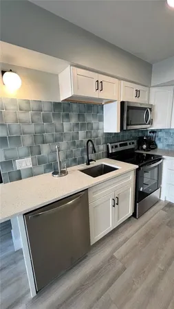 a kitchen with stainless steel appliances a sink stove and cabinets