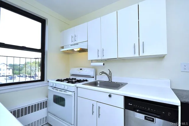 a kitchen with stainless steel appliances a sink stove and cabinets