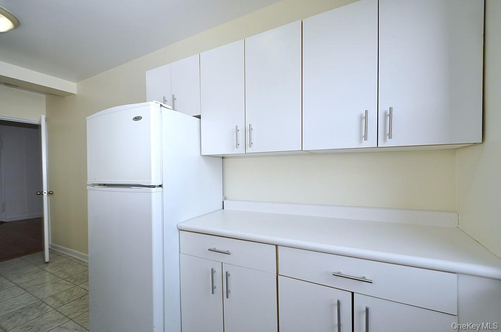142 Garth Road, Unit 4A Scarsdale, NY 10583 - Photo 11 of 44 a white refrigerator freezer sitting inside of a kitchen