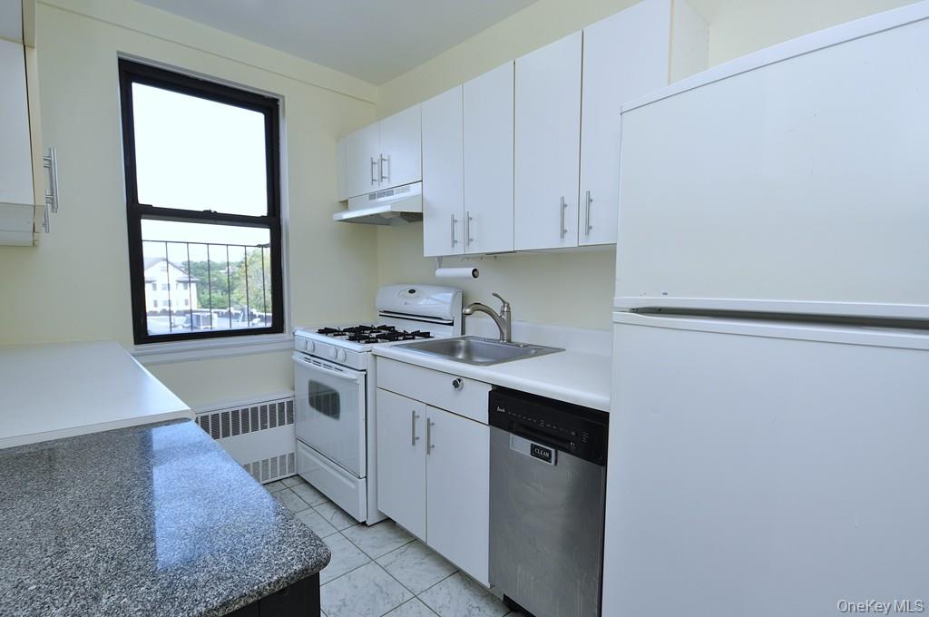 142 Garth Road, Unit 4A Scarsdale, NY 10583 - Photo 12 of 44 a kitchen with a sink cabinets and window