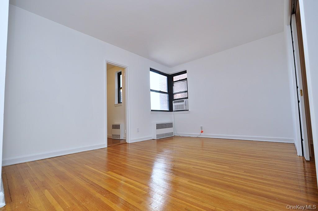 142 Garth Road, Unit 4A Scarsdale, NY 10583 - Photo 3 of 44 an empty room with wooden floor and windows