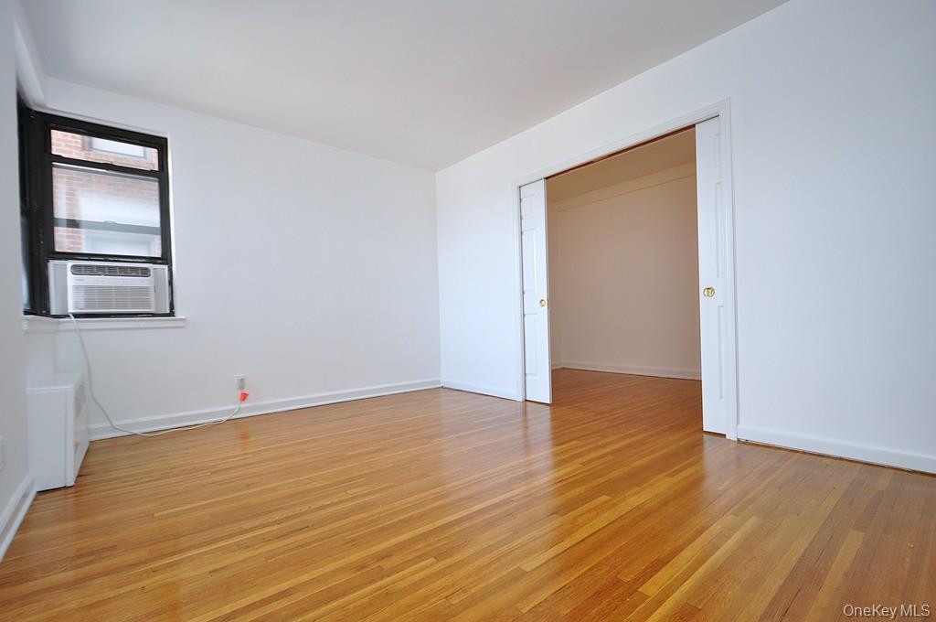 142 Garth Road, Unit 4A Scarsdale, NY 10583 - Photo 4 of 44 an empty room with wooden floor and windows