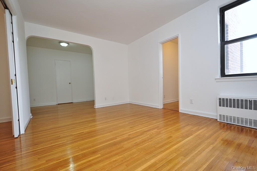 142 Garth Road, Unit 4A Scarsdale, NY 10583 - Photo 5 of 44 a view of an empty room with wooden floor and a window