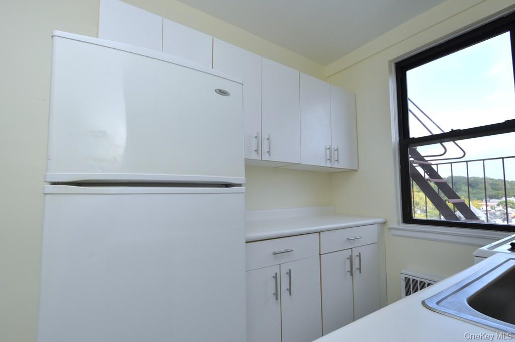 142 Garth Road, Unit 4A Scarsdale, NY 10583 - Photo 7 of 44 a kitchen with white cabinets and window