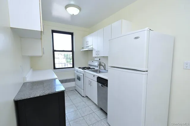 a kitchen with a refrigerator sink and cabinets