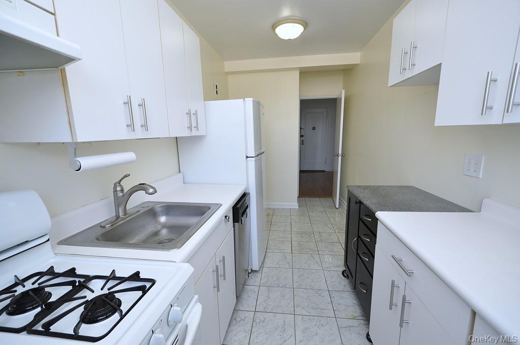 142 Garth Road, Unit 4A Scarsdale, NY 10583 - Photo 10 of 44 a kitchen that has a sink and a stove