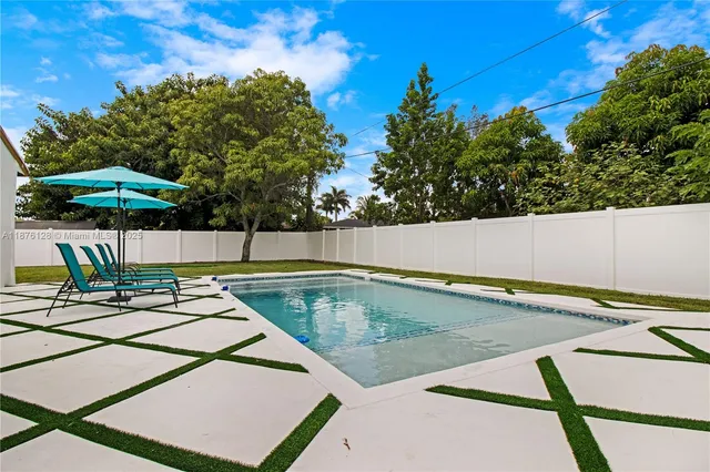a view of a patio with couches table and chairs under an umbrella