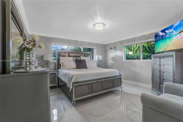 a bedroom with a bed couch and a potted plant