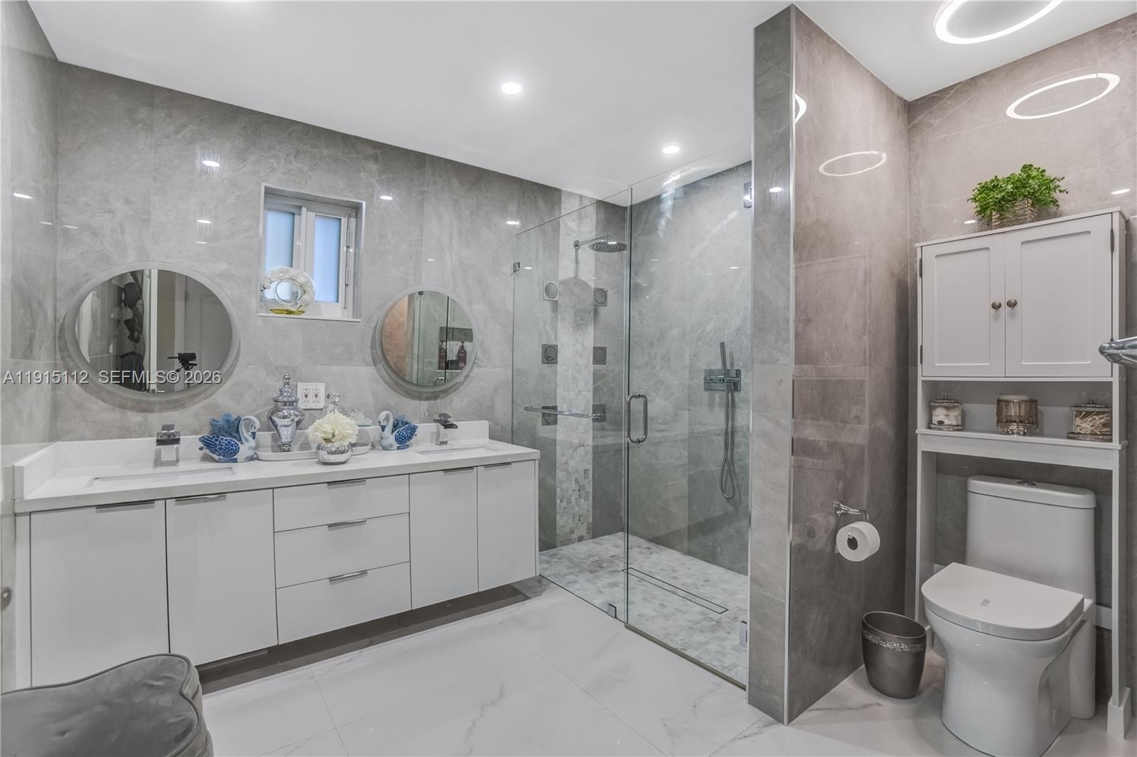 12601 Southwest 204th Street Miami, FL 33177 - Photo 13 of 40 a bathroom with a toilet a sink a mirror a shower and vanity
