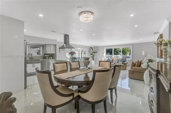 a living room with furniture a flat screen tv and floor to ceiling window